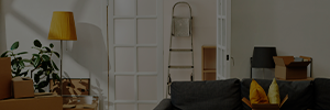 Fotografia de um apartamento com caixas e uma escada apoiada na parede
